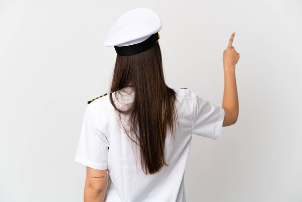 Brazilian girl Airplane pilot over isolated white background pointing back with the index finger - Photo, Image