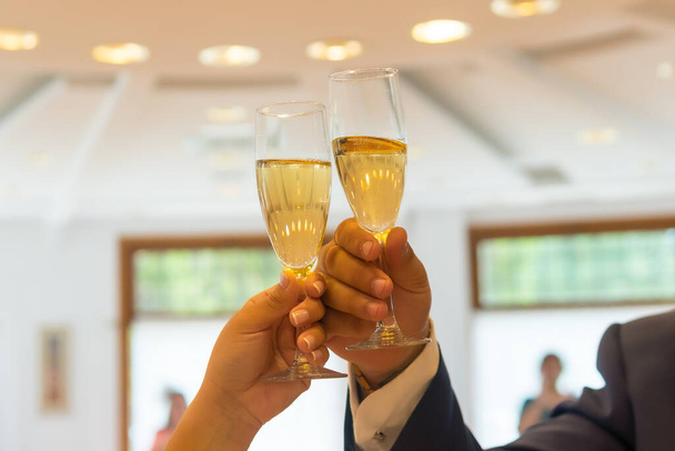 Hands of the groom and bride with rings toasting with glasses of champagne at a wedding celebration - Zdjęcie, obraz