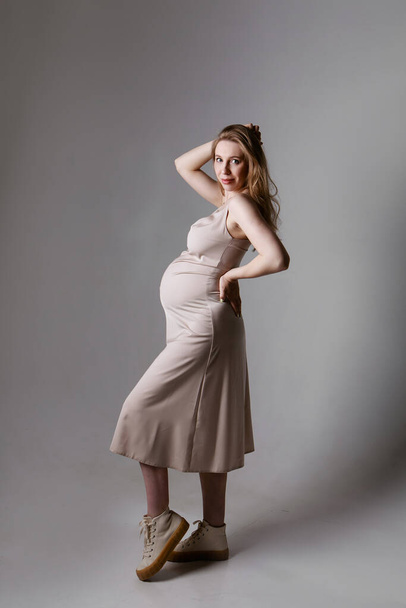 caucasian pregnant woman stroking her belly on white background. Copy space. The concept of healthy digestion, lifestyle, IVF - Fotografie, Obrázek