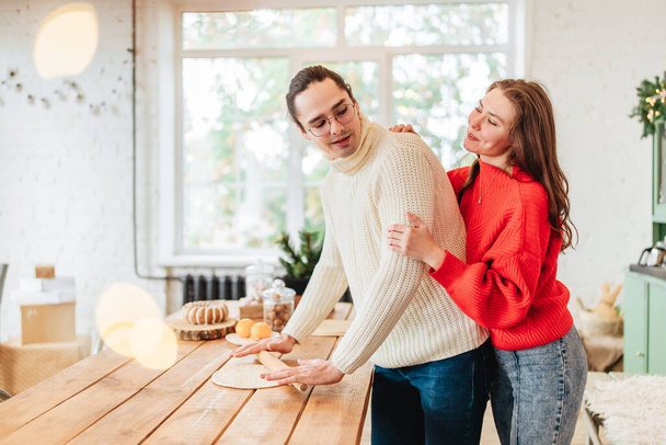 Young happy couple backing cooking at christmas winter holidays on the kitchen indoors ate home light image - Fotografie, Obrázek