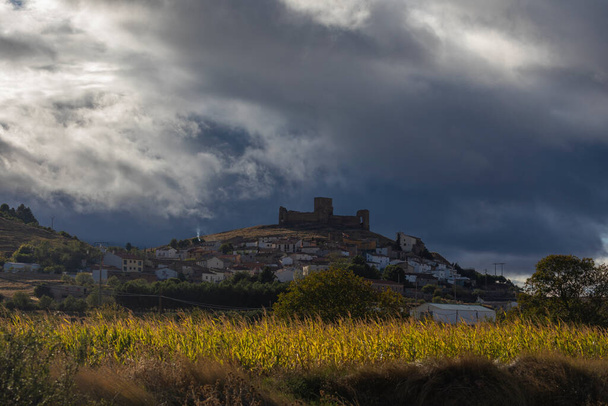 Vista de la pequeña ciudad de Trasmoz y su inconfundible castillo del siglo XII, contra un paisaje oscuro, atardecer y cubierto de nubes, Aragón - Foto, Imagen