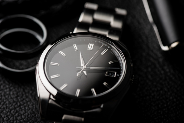 closeup πολυτελές αυτόματο ρολόι χειρός για άνδρες με μαύρο καντράν και βραχιόλι από ανοξείδωτο χάλυβα. - Φωτογραφία, εικόνα