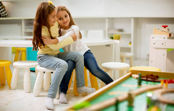 Two cute best friend girls together in the nursery playroom - Photo, Image