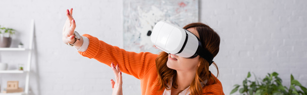 young woman in vr headset gesturing with outstretched hands, banner - Fotografie, Obrázek