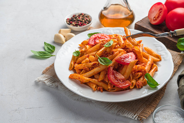 Tradiční italské těstoviny s rajčaty a masovou boloňskou omáčkou na šedém pozadí. Boční pohled, kopírovací prostor. - Fotografie, Obrázek