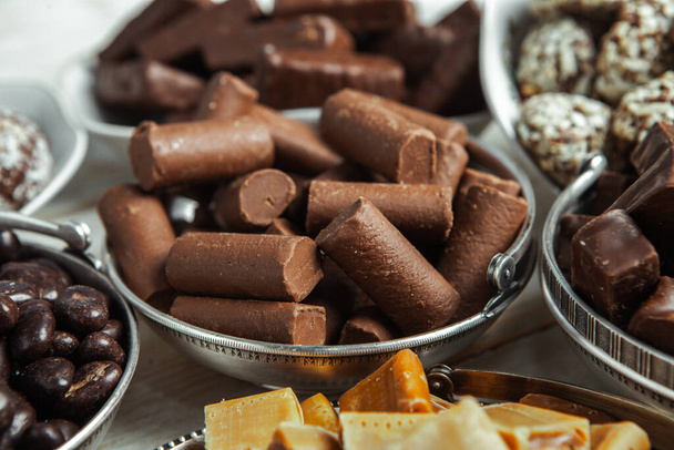 Асорті шоколадні цукерки на дерев'яному фоні. Шоколадні цукерки. Десертний фон
. - Фото, зображення