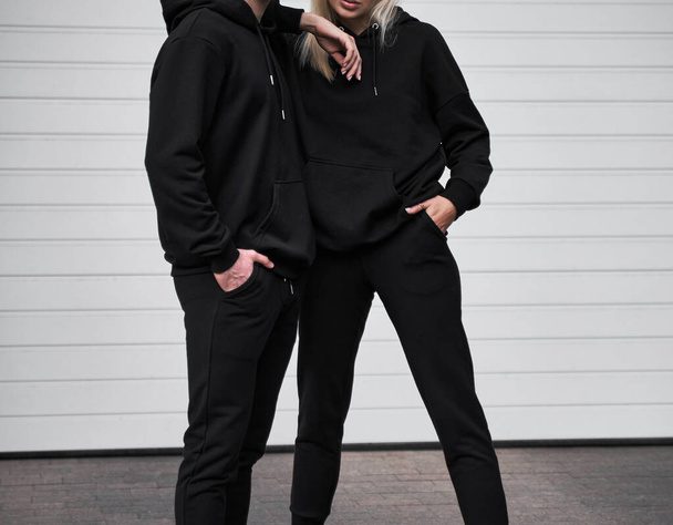 Frau und Mann tragen schwarzen Kapuzenpulli ohne Logo. Kein Logo, keine Sportbekleidung. Langarm-Sweatshirt-Attrappe - Foto, Bild