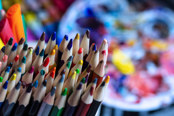 Un conjunto de lápices de colores en un soporte, sobre el fondo de los suministros de arte. Lápices en el escritorio del artista. - Foto, Imagen