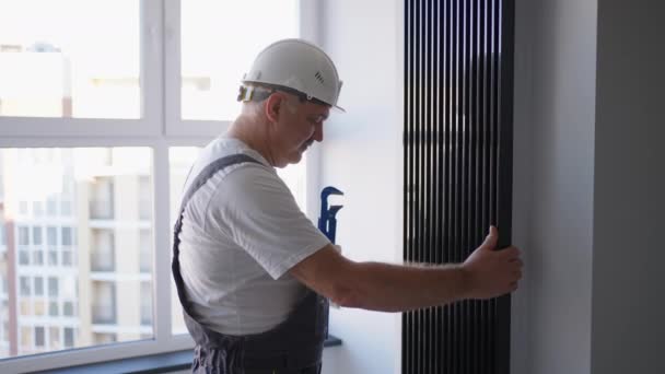 Ένας υδραυλικός ελέγχει τις μπαταρίες και το σύστημα θέρμανσης. Εποχή θέρμανσης - Πλάνα, βίντεο
