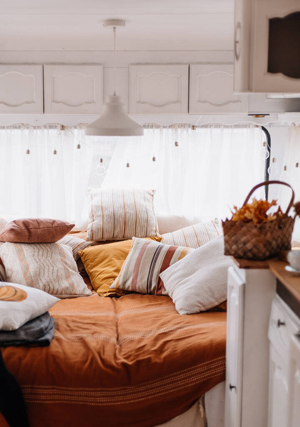 bed in trailer house. vintage style. cozy sleeping place with many pillows - Фото, зображення