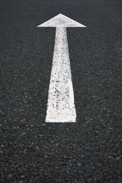 detalhe de um sinal de trânsito com uma seta branca pintada no asfalto. - Foto, Imagem