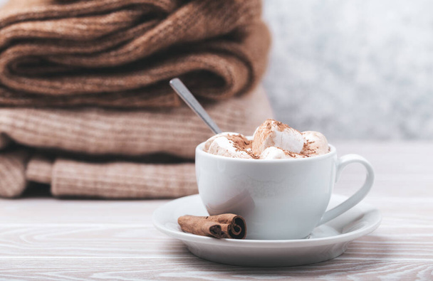 Cup of cacao and pile of knitwear - 写真・画像