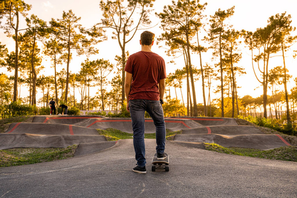 Skateboarder practice on a pump track park on a sunny day. - Foto, afbeelding