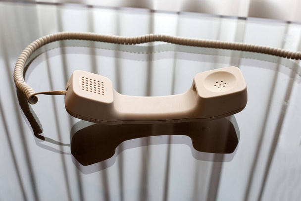 ακουστικό σταθερό τηλέφωνο σε γυάλινο τραπέζι - Φωτογραφία, εικόνα