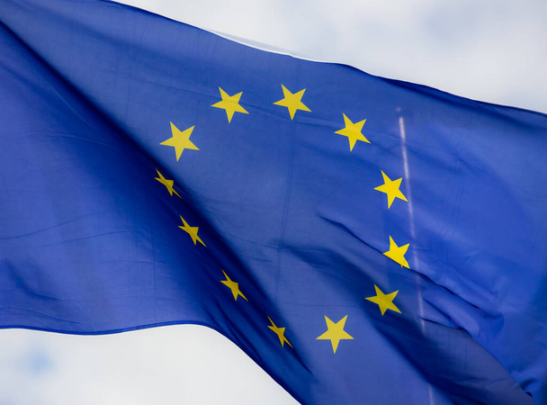 Euroopan unionin virallinen lippu sinisen taivaan edessä. - Valokuva, kuva