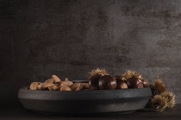 Modern design black ceramic bowl with autumn fruits. - Foto, Imagen