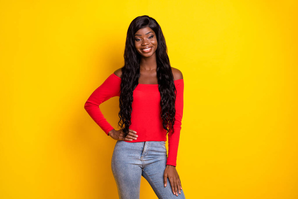 Photo of pretty sweet dark skin girl dressed red top arm waist standing isolated yellow color background. - Foto, Bild