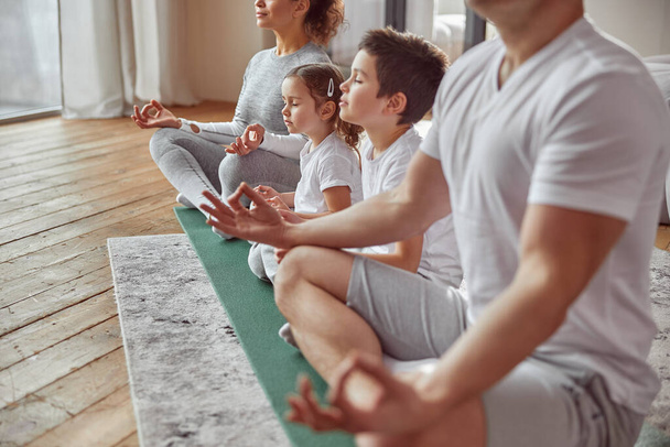 Padres haciendo meditación con niños en casa - Foto, imagen