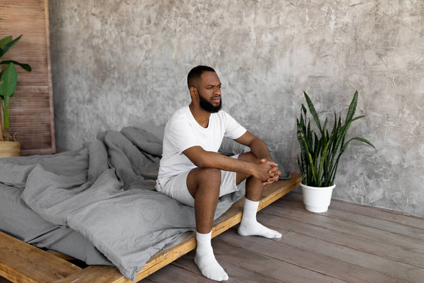 Black man sitting on bed and thinking - Photo, image