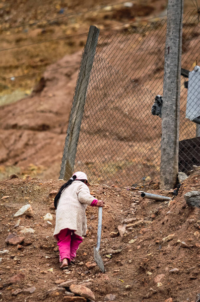 Πίσω όψη αγνώριστου παιδιού με φτυάρι στα ορυχεία αργύρου του Cerro Rico στο Potosi, Βολιβία, Νότια Αμερική. Το πλουσιότερο ορυχείο της αποικιακής εκμετάλλευσης στην ισπανική κατάκτηση στη Λατινική Αμερική που άφησε την πόλη σε συνθήκες φτώχειας. - Φωτογραφία, εικόνα
