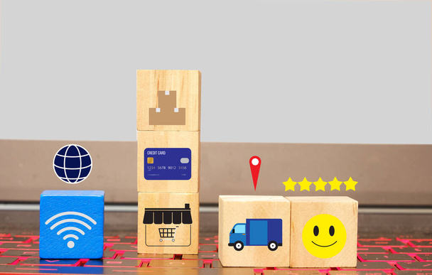 Een afbeelding van online shopping concept met houten blok bevatten symbool op laptop toetsenbord. Online winkelen is de meest gebruikte methode voor het kopen van goederen tijdens covid-19. - Foto, afbeelding