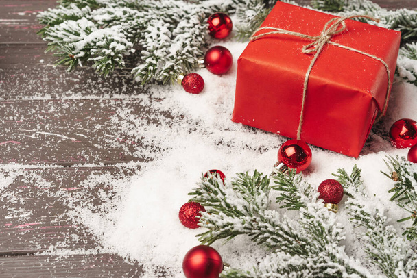 Christmas gift on wooden table powdered with snow - Valokuva, kuva