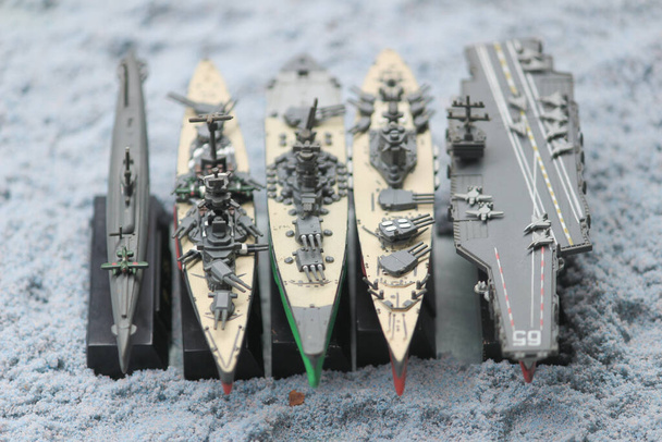 La alineación de acorazados en miniatura consiste en el portador de la empresa, el submarino, el acorazado Musashi, el acorazado Yamato, el acorazado principal Bismarck, y el acorazado principal Rodney. - Foto, imagen