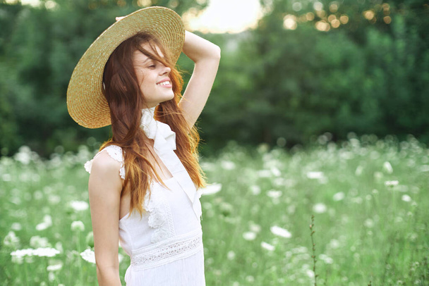 cheerful woman in a white dress on nature flowers walk - 写真・画像