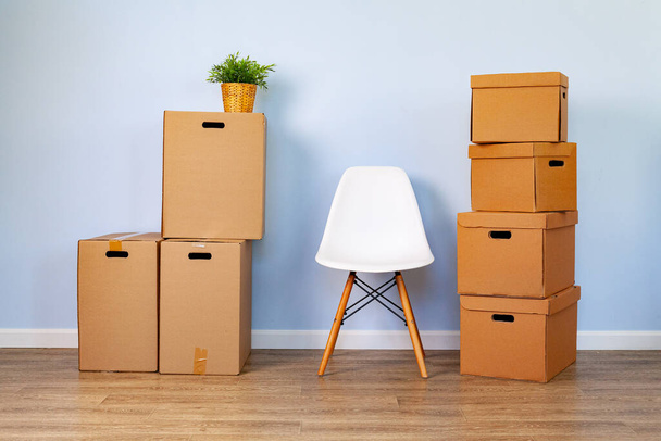 Moving boxes with packed stuff and chair for moving - Φωτογραφία, εικόνα