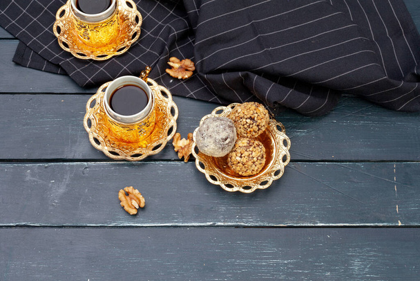 Nut balls dessert served with coffee on dark wooden table, top view - Photo, Image