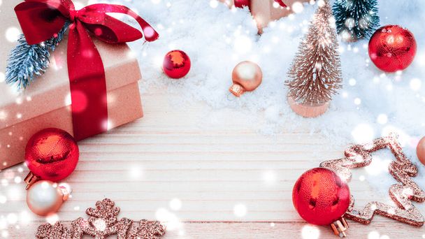 Tavola di sfondo di Natale. Decorazione invernale in legno sfondo. Tavola natalizia con vecchia parete rustica, neve bianca ghiacciata, palline d'oro e confezione regalo. Nuovo regalo di fiocco rosso anno - Foto, immagini