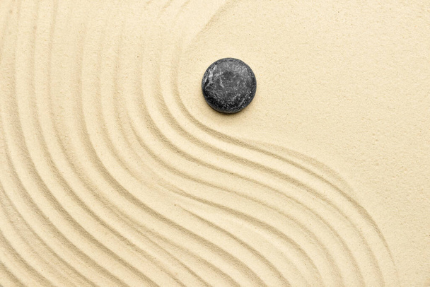 Piedra spa negra sobre arena clara - Foto, Imagen