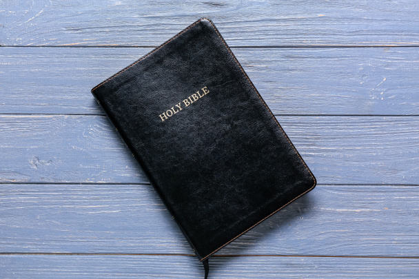 Черная Священная Библия на синем деревянном фоне - Фото, изображение