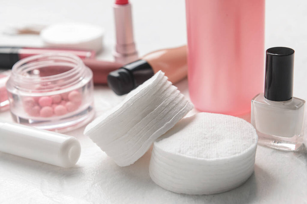 Almohadillas de algodón limpias, botella de esmalte de uñas y cosméticos en la mesa blanca, primer plano - Foto, imagen