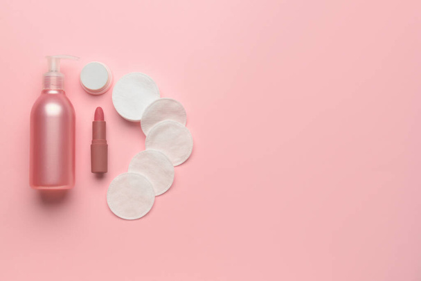 Lotion bottle, lipstick and cotton pads on pink background - Photo, Image