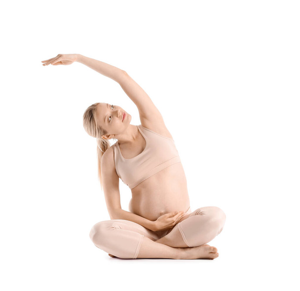 Fiatal terhes nő gyakorló jóga fehér háttér - Fotó, kép