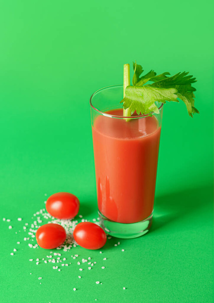 Glass of bloody mary with celery and tomatoes on color background - Photo, Image