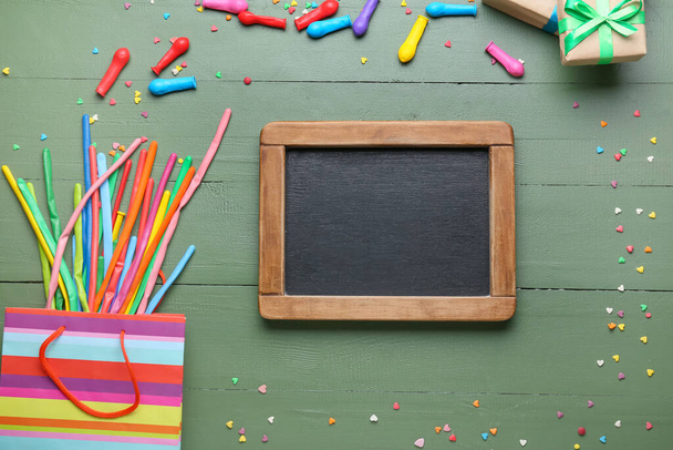 Gift bag with balloons and chalkboard on color wooden background - Φωτογραφία, εικόνα