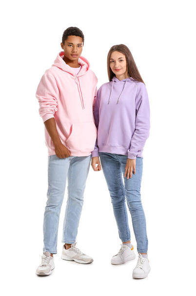 Stylish young couple in hoodies on white background - Foto, Imagen