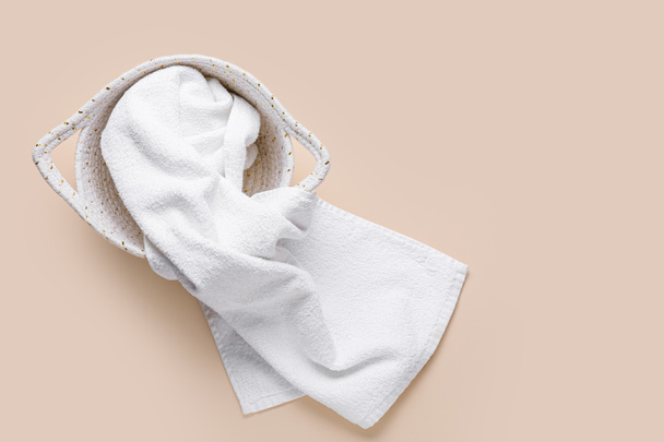 Cesto con asciugamano bianco pulito su sfondo colore - Foto, immagini