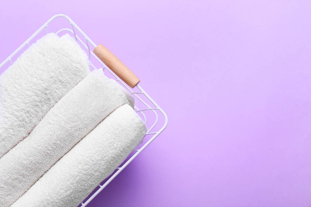 Cesta com toalhas limpas sobre fundo lilás, close-up - Foto, Imagem