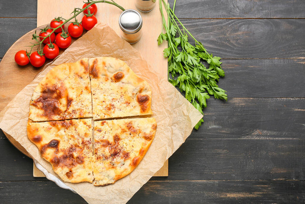 Board with delicious khachapuri and spices on wooden background - Φωτογραφία, εικόνα