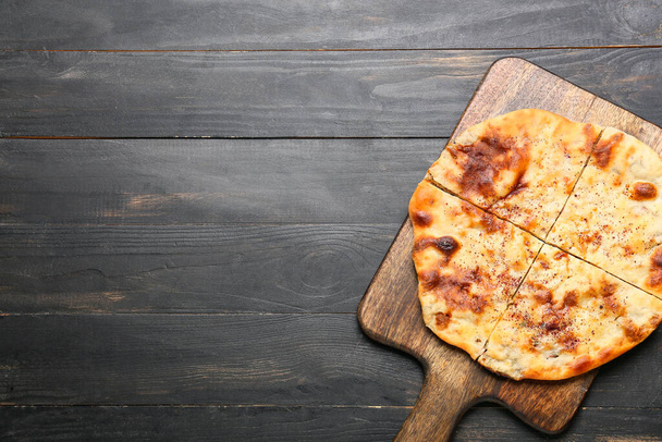 Board with tasty khachapuri on wooden background - Photo, image