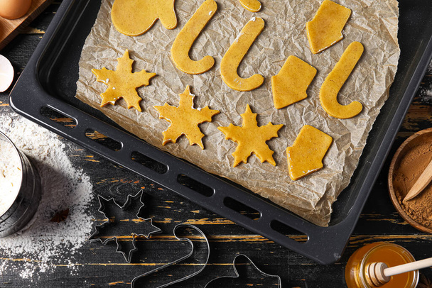 Baking sheet with raw Christmas cookies on dark wooden background - Photo, Image