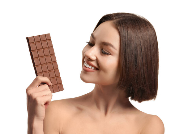 Beautiful young woman with sweet chocolate on white background - Photo, Image