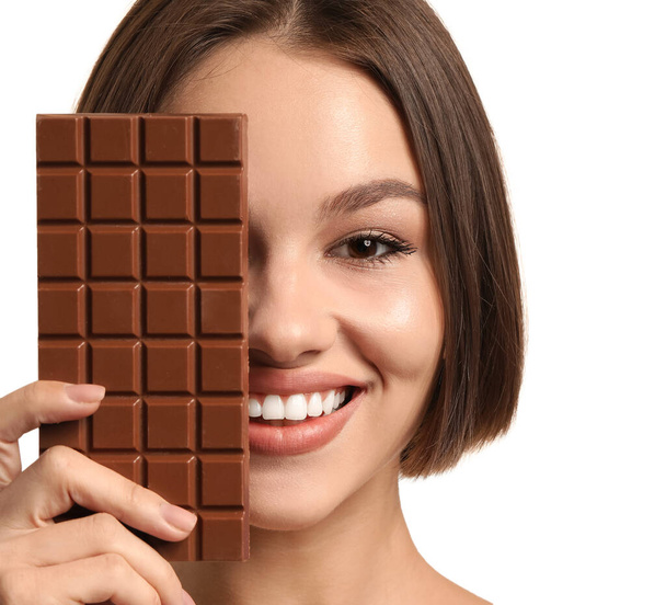 Beautiful young woman with sweet chocolate on white background - Photo, Image