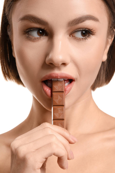 Piękna młoda kobieta ze słodką czekoladą na białym tle - Zdjęcie, obraz