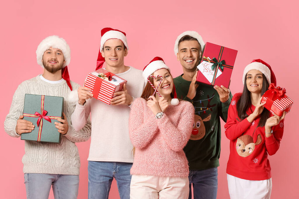 Grupo de amigos con regalos de Navidad y bastones de caramelo sobre fondo de color - Foto, imagen