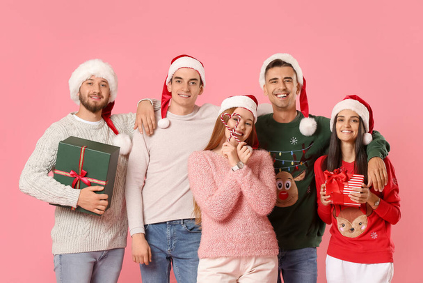 Ομάδα φίλων με χριστουγεννιάτικα δώρα και καραμέλα μπαστούνια στο φόντο χρώμα - Φωτογραφία, εικόνα