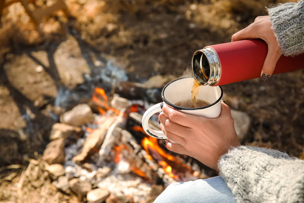 Woman drinking hot tea in autumn forest - Photo, Image